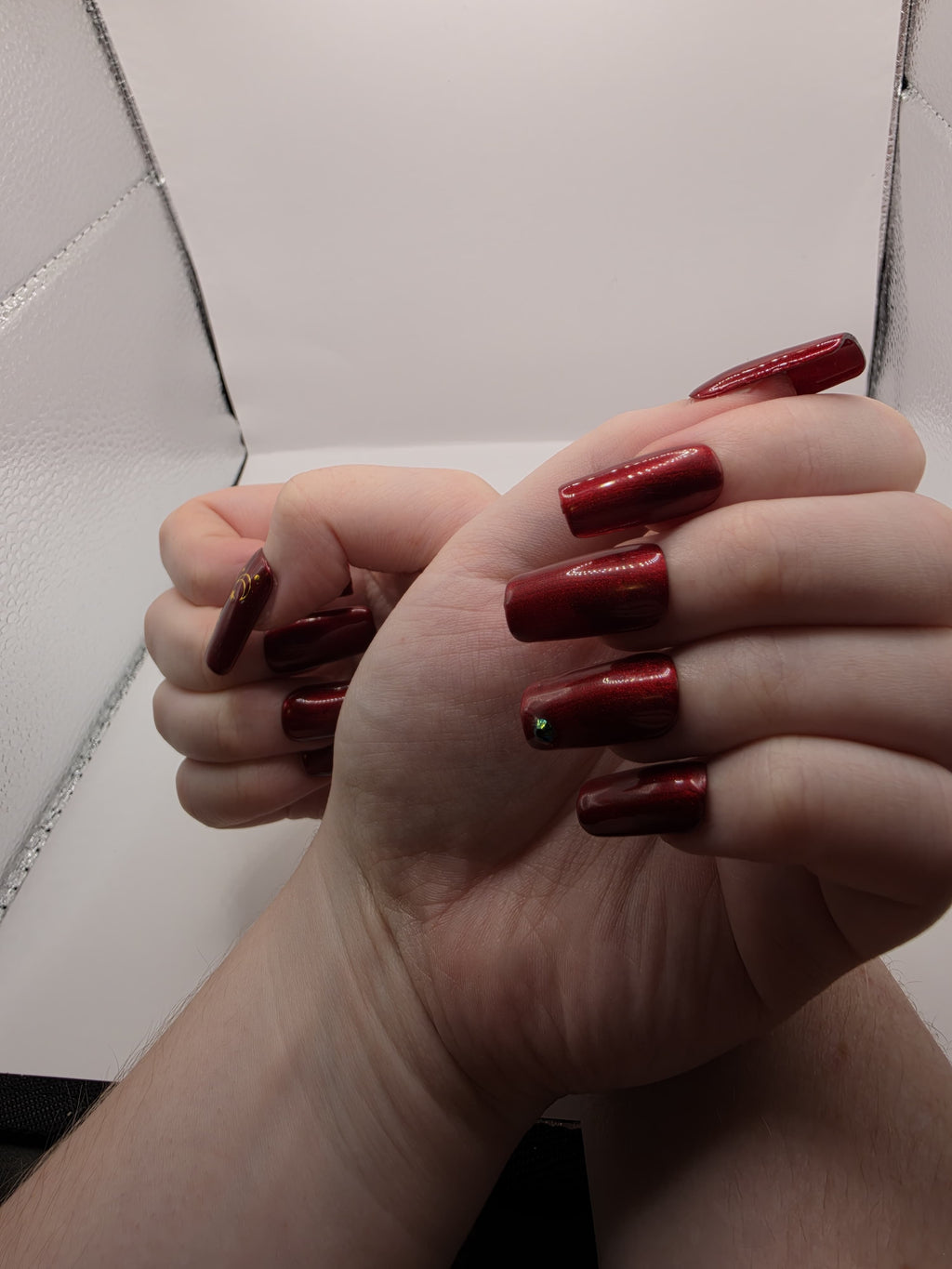 #59 Base Coat: Red shimmer base coat with black opalescent gem on ring fingers and gold moon and star motiff on the thumbs featured on medium square nails