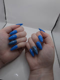 #141 Base Coat with #210 accent nail (catseye): A striking dark sky blue base color with an accent nail on the ring fingers featuring a glittery silver diagonal catseye displayed on medium length almond nails