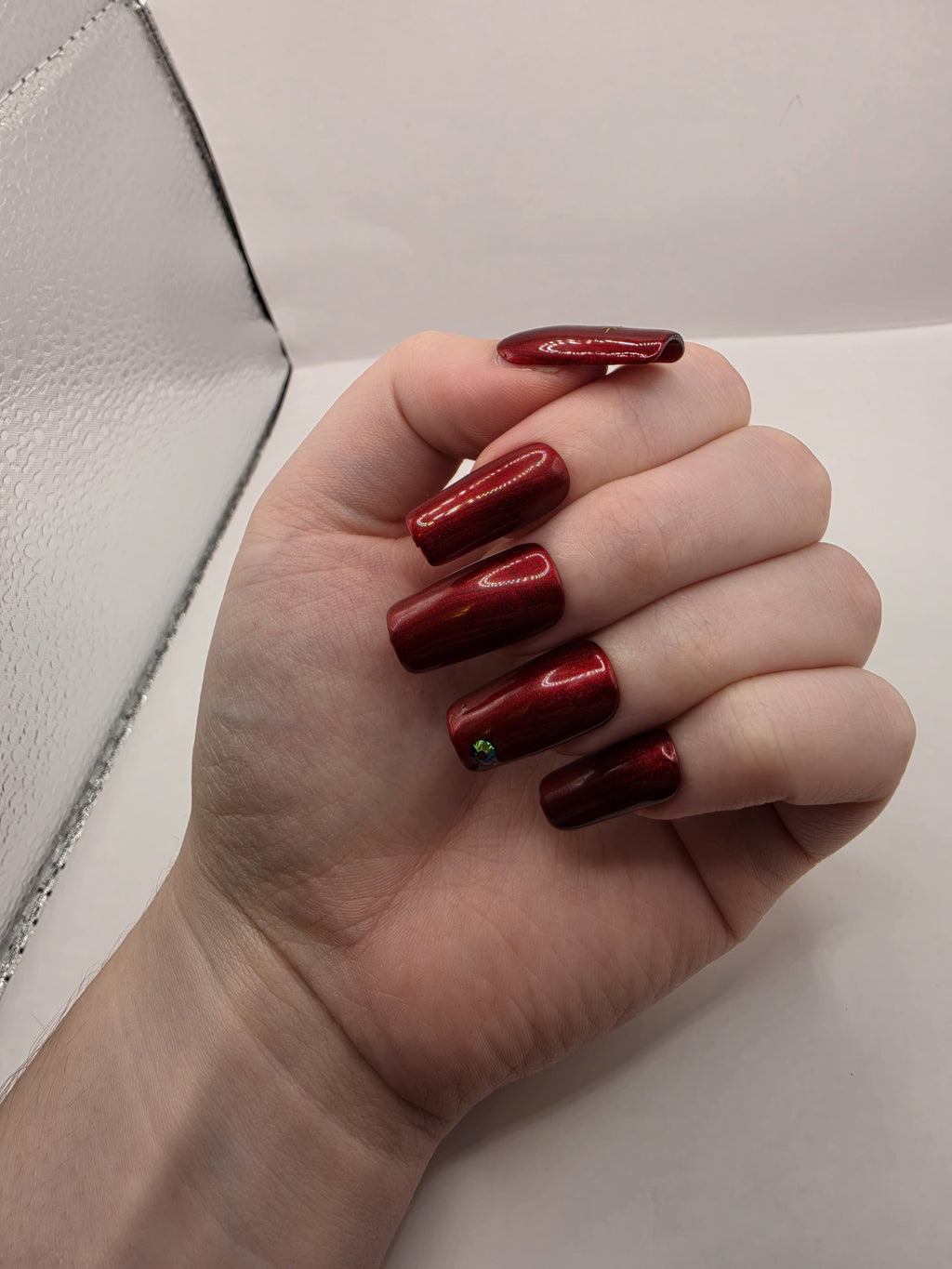 #59 Base Coat: Red shimmer base coat with black opalescent gem on ring fingers and gold moon and star motiff on the thumbs featured on medium square nails