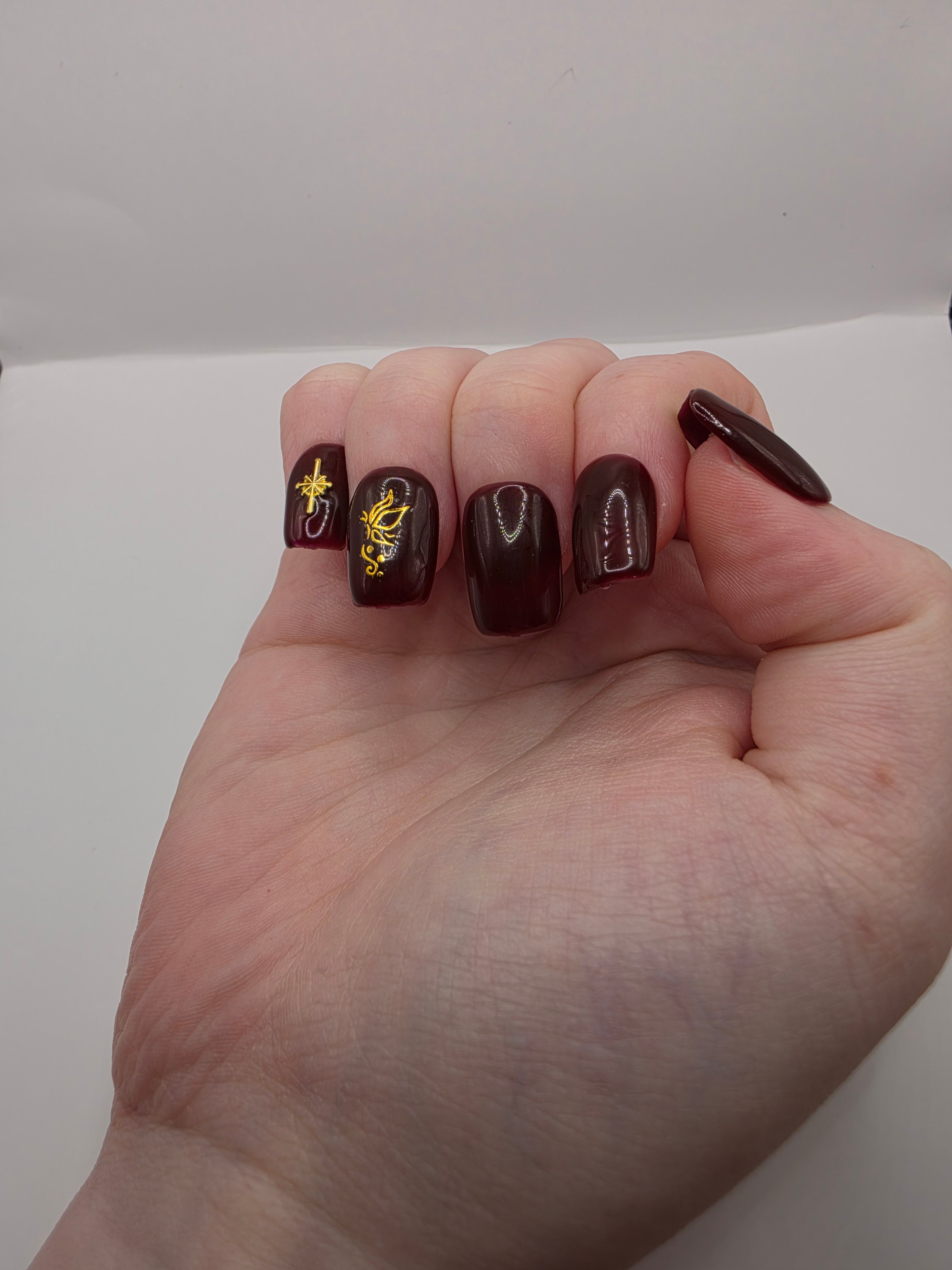 #158 Base Coat: A deliscous dark berry shade with brown undertones decorated with a butterfly design on the ring fingers and an elongated eight-pointed star charm inbedded into the pinky nails designed on short square nails