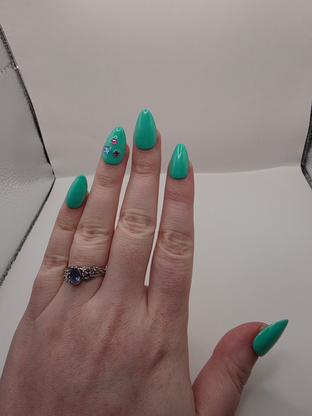 #147 Base Coat: A summery sensational turquoise with three different colored flower charms (purple, light blue, and hot pink) inbedded into the accent ring finger nail featured on short almond nails