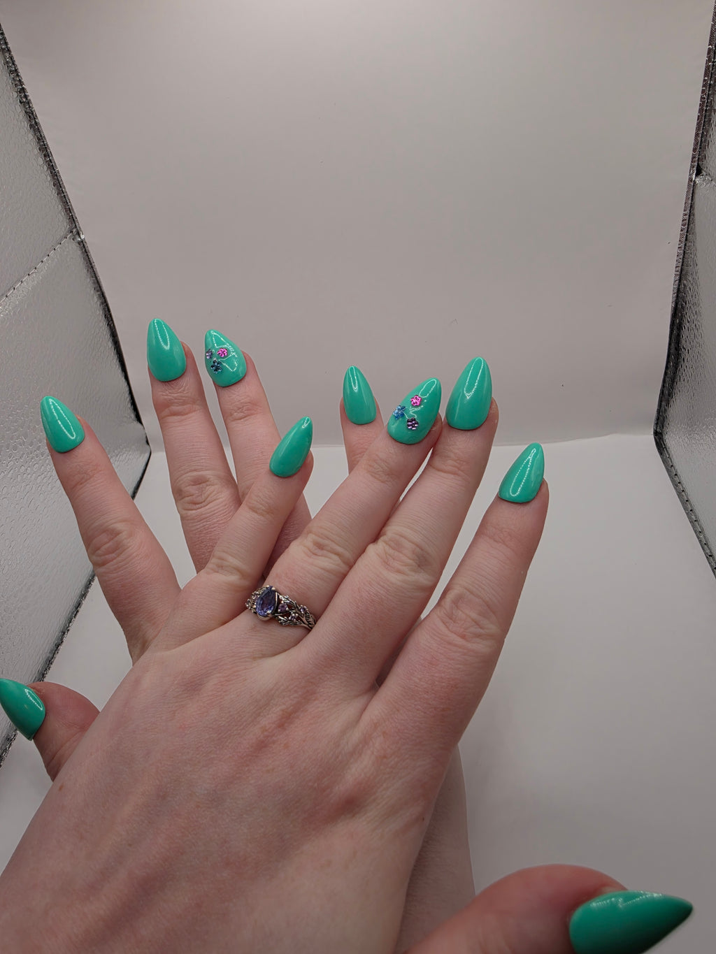 #147 Base Coat: A summery sensational turquoise with three different colored flower charms (purple, light blue, and hot pink) inbedded into the accent ring finger nail featured on short almond nails