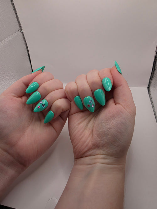 #147 Base Coat: A summery sensational turquoise with three different colored flower charms (purple, light blue, and hot pink) inbedded into the accent ring finger nail featured on short almond nails